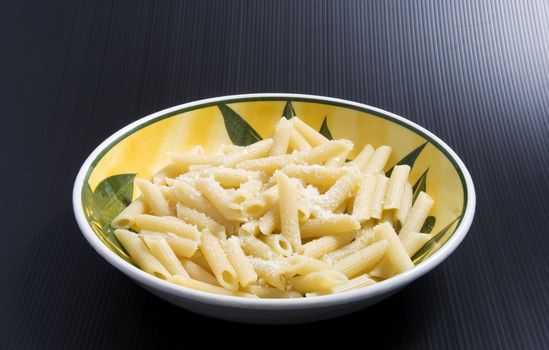 A plate full of italian pasta (maccheroni al burro), over a black background