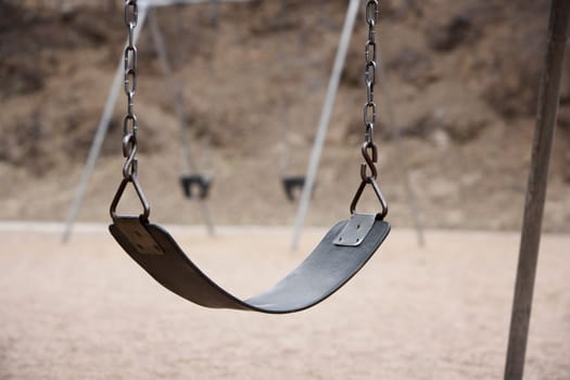 Old style playground swing with chains and rubber seat