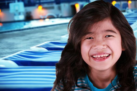 Smiling child by poolside at dusk