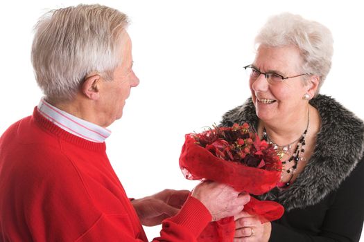 Senior couple celebrating valentines day with the man giving his wife a valentine bouquet