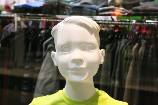 Dummy with a smile behind glass in shop