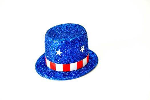 A top hat made of blue glitter decorated in a patriotic theme.