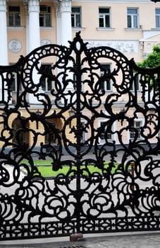 wrought iron gates with classical style building as background