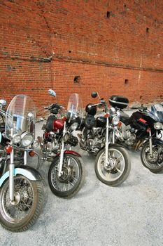 Four motorcycles on a background of a brick wall