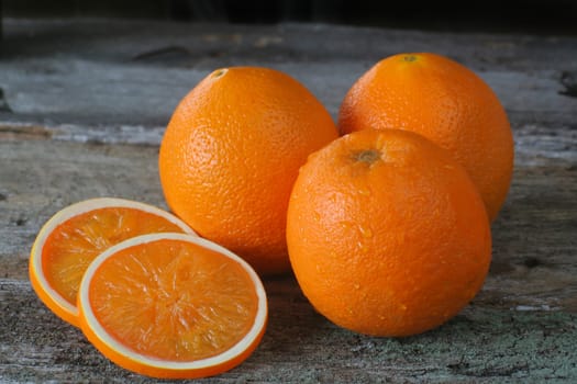 Fresh ripe oranges whole and sliced.