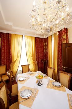 Greater chandelier above a greater dining table