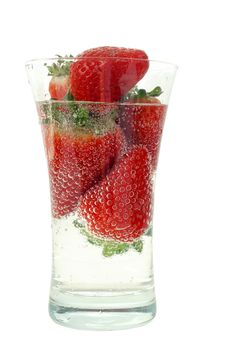 Big fresh strawberry in glas with bubble water isolated