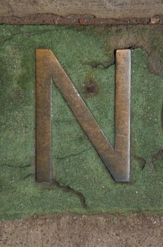 The letter N is encased in marble on the sidewalk in downtown Denver.