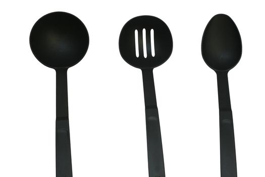 three sizes of kitchen ladles on an isolated black background