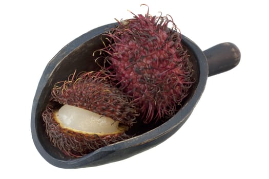 rambutan fruits on a rustic wooden scoop isoalted on white