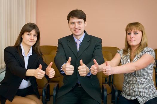 Team of cheerful businessmen show thumb up