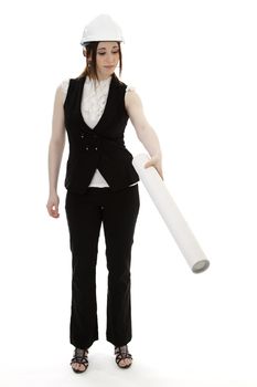 Young business woman wearing a business suit and construction had holding a white tube and pointing down against a white background 