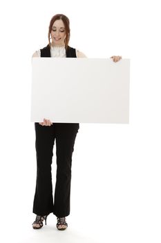 Young business woman wearing a business suit with a happy expression looking down on a white board against white background