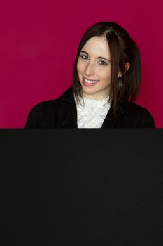 Young woman popin out from behing a black board
