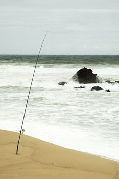 Sticked fishing rod by the beach