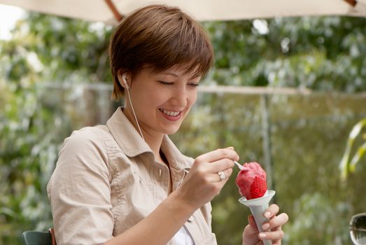 The happy woman with fruit ice-cream 