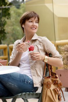 The happy woman with fruit ice-cream