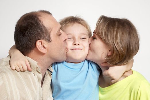 Happy parents kissing son