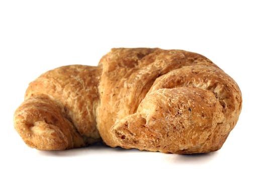 Part of a delicious continental breakfast: fresh baked healthy whole wheat croissant on white background.