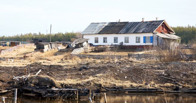 The old crooked shabby rural wooden house