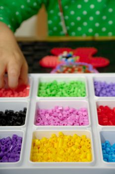 Hand of child is playing with toy pearls