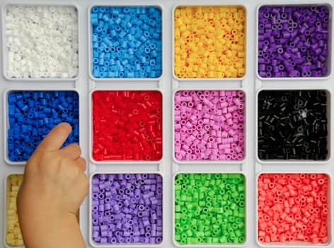Hand of child is playing with toy pearls