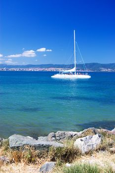 Sea shore and the yacht over bluee sky