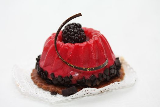 red fruitcake with chocolate and bramble decoration