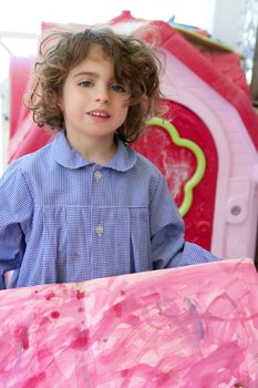 Beautiful preschooler student little girl showing her pink artwork