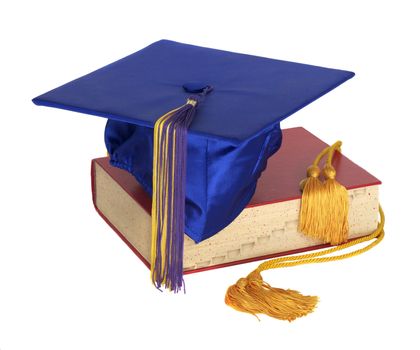 A graduation hat and honor cord on top of a text book
