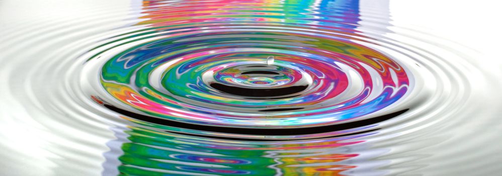 A drop ripples through the water reflecting a psychedelic background.
