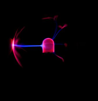 A single finger touching a plasma bulb