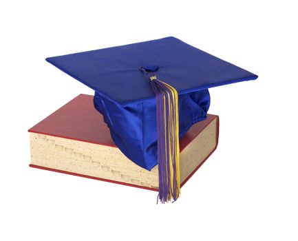 A colorful graduation cap resting on top of a text book.