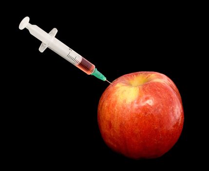 Red apple with a syringe on black background