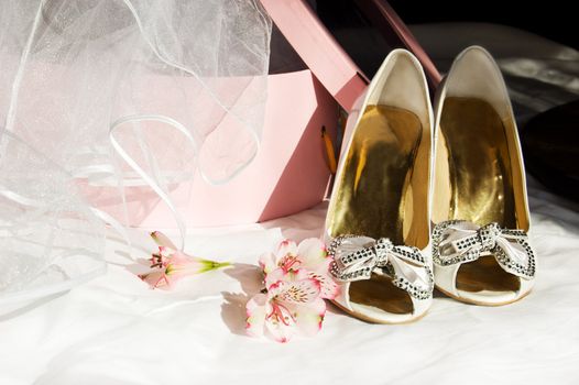 Wedding shoes, veil and box over dark background