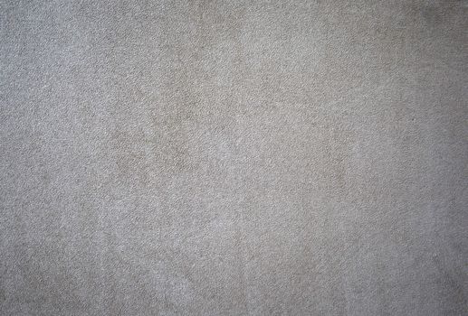 A background or texture of a beige colored suede swatch