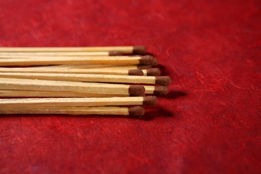 Arrangement of wooden light matches over red background