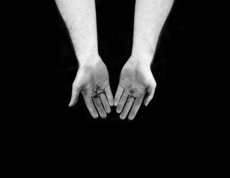 Dirty hands on a black backdrop in black and white