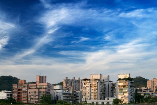 Here is a cityscape of apartment with blue sky.