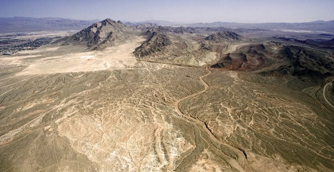 Lifeless dry desert with several picks in a hot weather