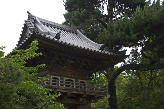 Oriental house in japanese garden through the trees