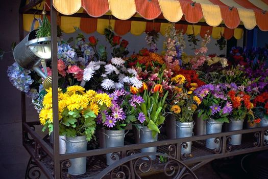 Bouquets of multicolored flowers for sale on the sidewalk