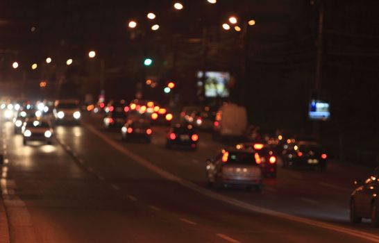 Defocused night scene of traffic lights and cars. 