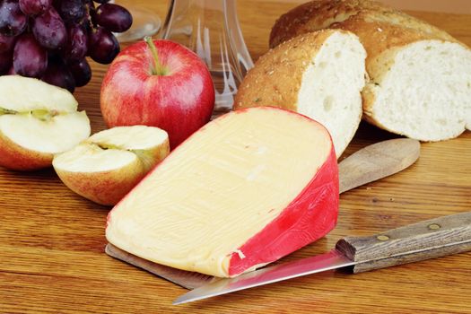 Dutch Edam cheese with fresh fruit and a loaf of bread.