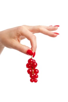 Female hand with long red fingernails holding the red currants