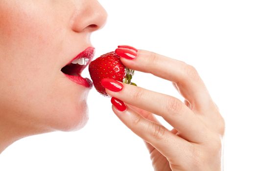 Beautiful woman taking a bite of a ripe red strawberry