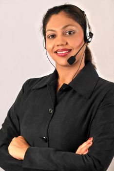 Smiling young Indian agent woman of a call center. Isolated over grey background