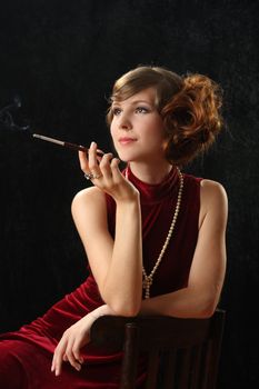 The beautiful girl smokes a thin cigarette