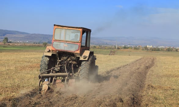 Image of a field with a tractor ploughing. 