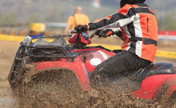 Detail of an ATV during the muddy race.The main focus is on the mud drops.